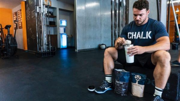 hombre haciendo un batido con proteina de whey en el gimnasio