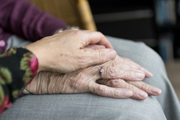 close up of a younger hand holding an older hand