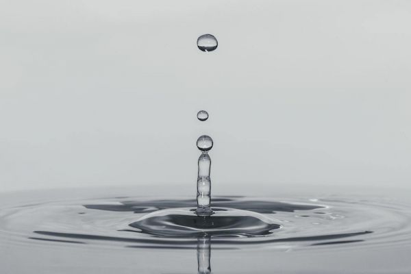 a drop of water falling into a body of water