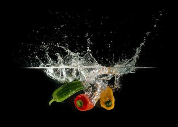 Tres pimientos, una verdes, uno rojo y uno amarillo en el agua