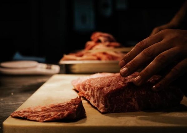 Un hombre cortando carne