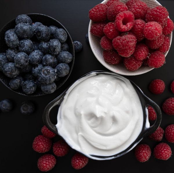 yogurt in a bowl with spoons,healthy breakfast with fresh greek yogurt, muesli and berries on background