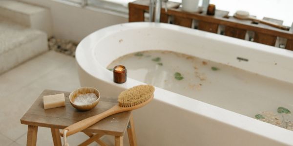 An image showcasing a soothing foot bath for relieving restless leg syndrome, featuring a wooden basin filled with warm water, Epsom salts, and dried lavender.