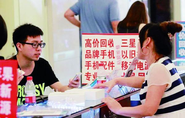 一名消費(fèi)者在手機(jī)交易市場內(nèi)咨詢手機(jī)回收業(yè)務(wù)