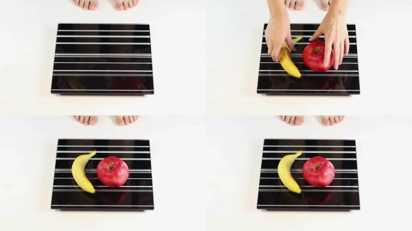 香蕉和苹果在电子秤上。保健和健康的生活方式。节食,控制体重,生活中要有运动。