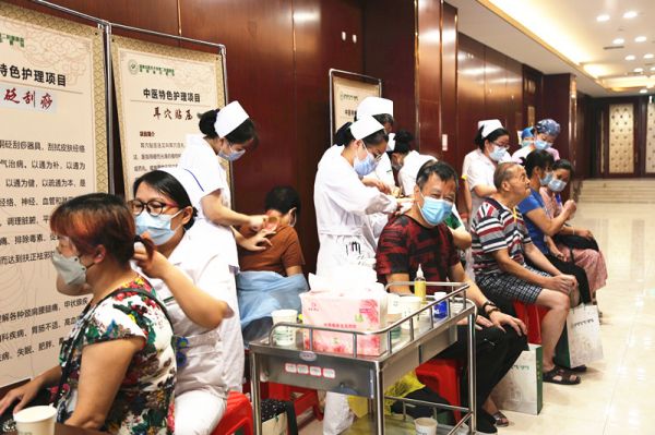 湖南省中医院的医护人员为活动现场的老年朋友进行公益理疗。