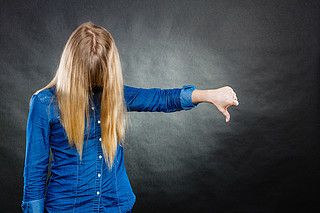 身体语言，暗示。抑郁和辞职的概念。年轻的沮丧不快乐的女人用金发遮住面部情绪。沮丧的金发女人遮住脸。