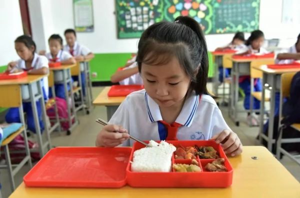 ▲黑龙江省明水县某学校三年级学生在吃营养午餐。图/新华社