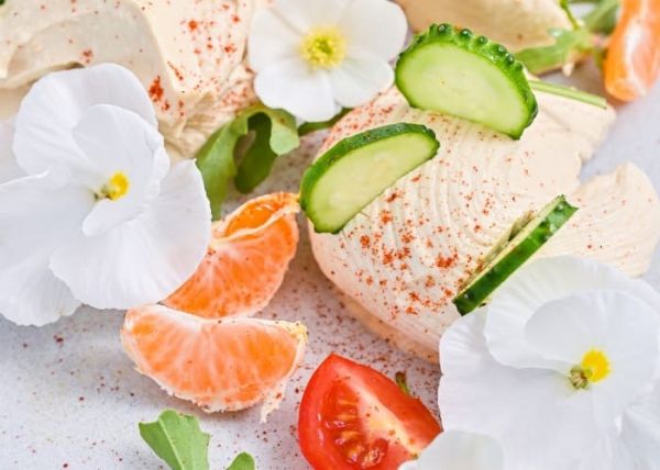 Un plato de hummus, pepino y mandarinas