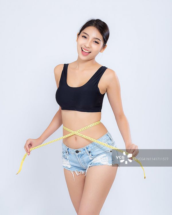 美麗的肖像亞洲婦女節(jié)食和苗條與測量腰圍體重孤立在白色的背景，女孩有脂肪團(tuán)和熱量損失與卷尺，健康和健康的概念。圖片素材