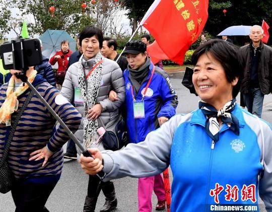 一名参加健步行活动的女性市民使用手机自拍杆自拍。　记者刘可耕 摄