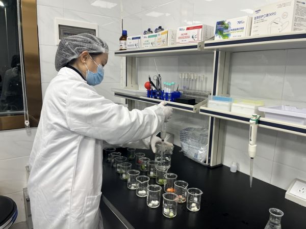 工作人員在快檢室對蔬菜取樣檢測。