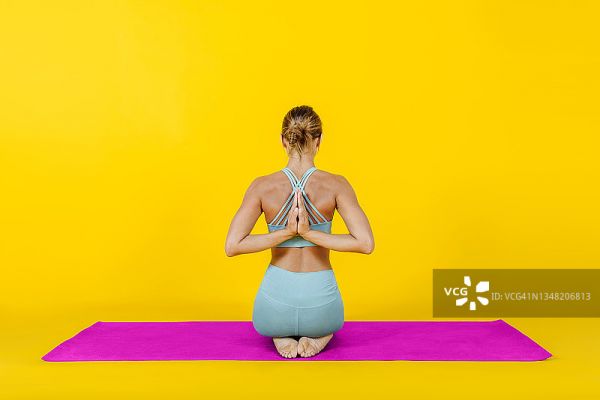 一個健康的女人在瑜伽墊上做背部練習冥想。運動與健康生活方式圖片素材