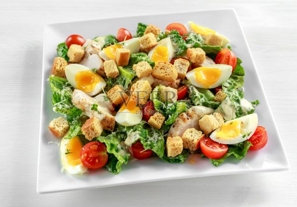 新鲜健康的凯撒沙拉，配有鸡肉，鸡蛋，西红柿，奶酪和油炸面包丁照片摄影图片