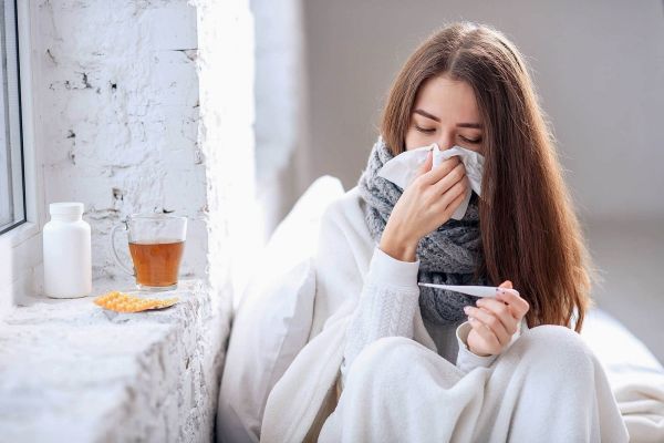 Chica resfriada se mide la temperatura