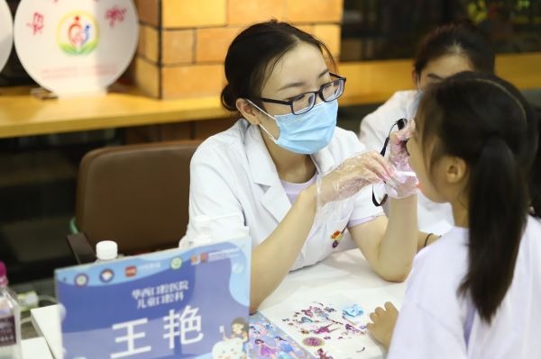 四川大学华西口腔医院儿童口腔科副主任医师王艳为小朋友进行口腔检查