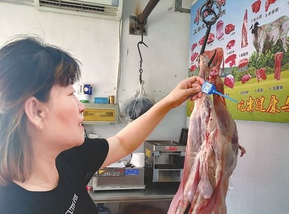 圖一：西仰陵農(nóng)貿(mào)市場負(fù)責(zé)人高淑紅告訴記者，每批次鮮肉都有可以追溯來源的二維碼小藍(lán)卡。