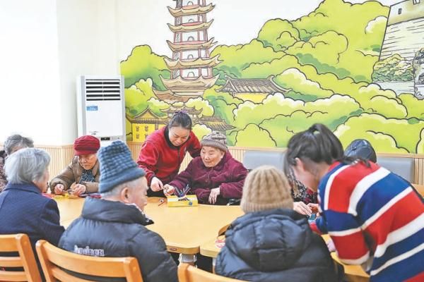 1月22日，在宁波市镇海区金生怡养院，护理员陪着失能老人在休闲区玩益智游戏。2023年1月，宁波率先实现长期护理保险全域覆盖，全市所有区域医保参保人全部被纳入保障范围，提供机构护理和居家护理两种选择。