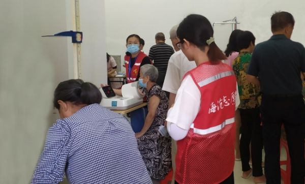 志愿者現(xiàn)場協(xié)助為老年人進行體檢服務