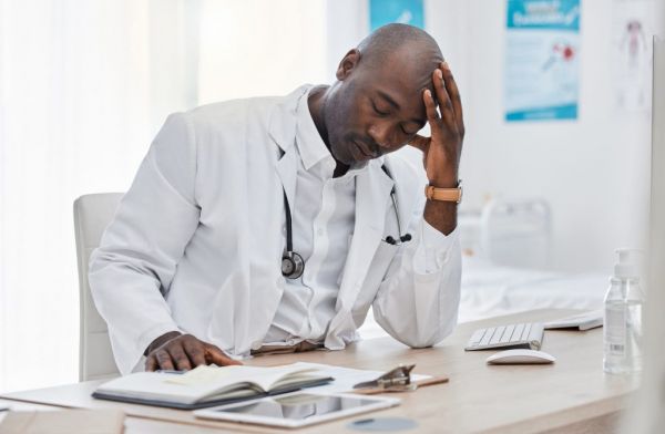 Stress, anxiety and sad doctor, medical professional and healthcare worker with negative test results on technology. Thinking gp with burnout headache or bad news in clinic, hospital or health center.