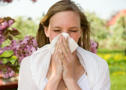 A young woman blowing her nose