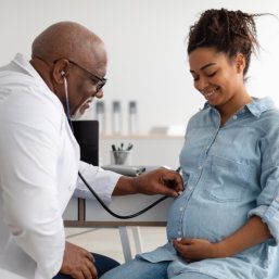 doctor examining young pregnant woman