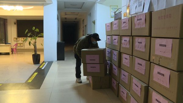 普定縣衛(wèi)生健康局工作人員搬運“防疫健康包”物資。