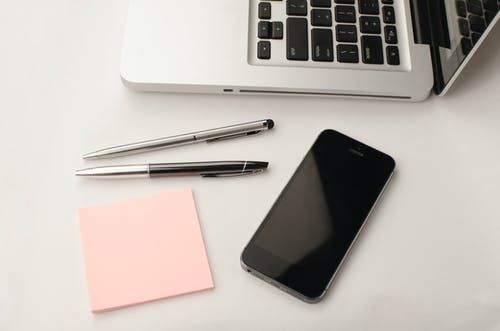 兩只可伸縮筆和macbook旁邊的太空灰iphone 6
