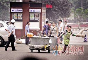 商販們拖著早餐車極不情愿地撤退 李文彬攝