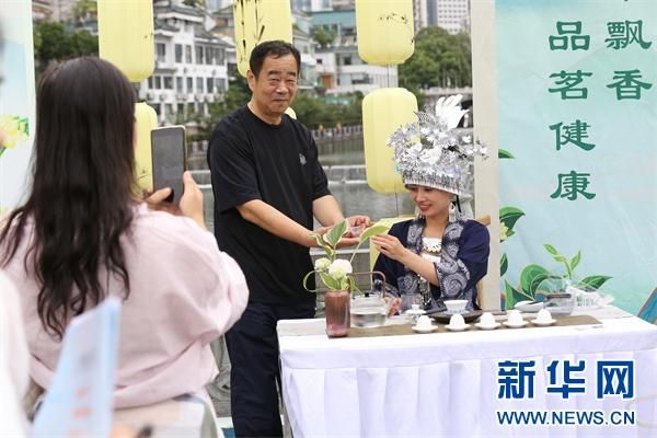 7月14日,一名游客在甲秀楼景区品茶留影。新华网 黄勇 摄