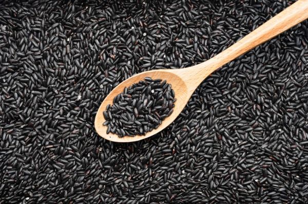 a spoonful of black rice on a pile of black rice
