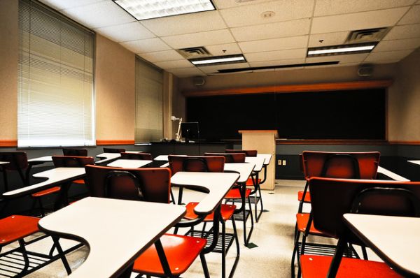 This image is the same as the issue cover, an empty classroom with white desks and red chairs