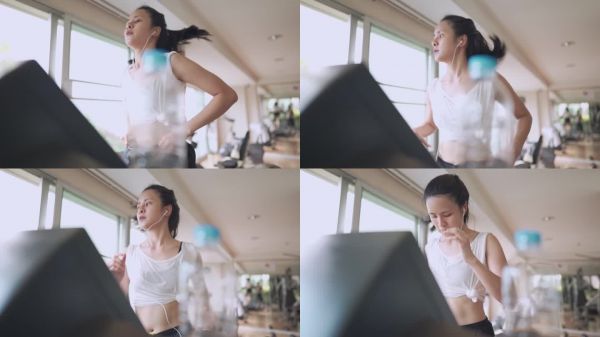 年輕美麗的亞洲女人獨自在跑步機上跑步在公共健身房，做有氧運動，減肥訓(xùn)練計劃，現(xiàn)代健康生活，耐力活力，