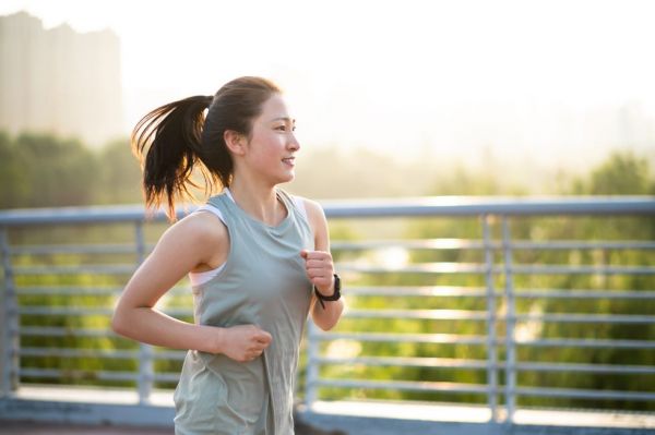 asian young woman running in the city street in the morning