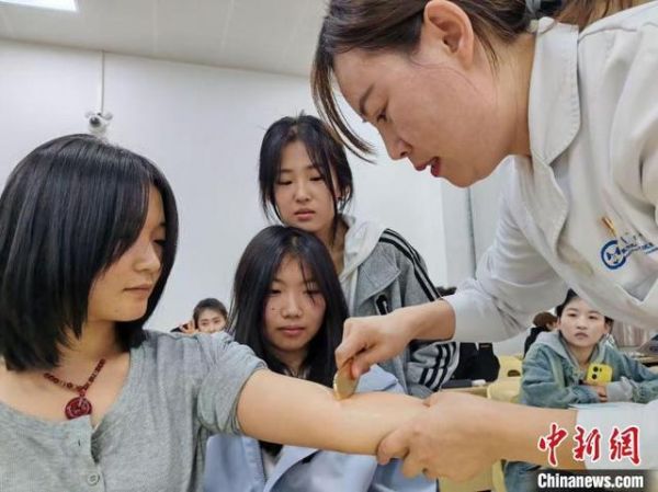 学生体验刮痧。 王嵘 摄
