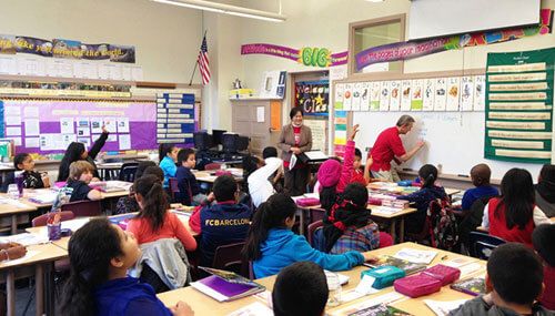 在希望工程举办的《未来理财教育计划》中，华美银行的义工为孩童进行理财教育。