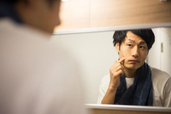 鏡を見る男性