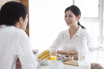 Newlyweds are facing are eating breakfast