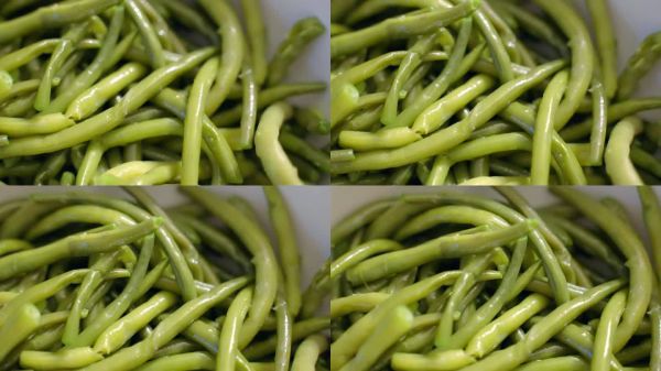 白碗煮熟的四季豆配以天然橄榄油和蒜末调味，健康的天然食材烹饪，新鲜的绿色蔬菜健康的生活方式