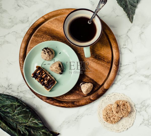 生的健康糖果，自制素食士力架和饼干。糖果和一杯咖啡。喝咖啡或吃早餐。大理石的背景。前视图。照片摄影图片