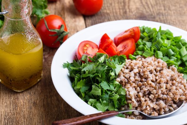 健康的煮荞麦谷物沙拉配新鲜的绿洋葱，欧芹和西红柿照片摄影图片