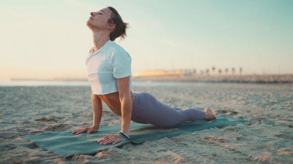 woman stretching exercising on yoga mat outdoors 2022 11 23 19 06 05 utc 瑜珈身體變化, 瑜珈對身體的好處, 瑜珈對心靈的好處, 瑜珈好處, 瑜珈對身心的好處, 瑜珈的好處