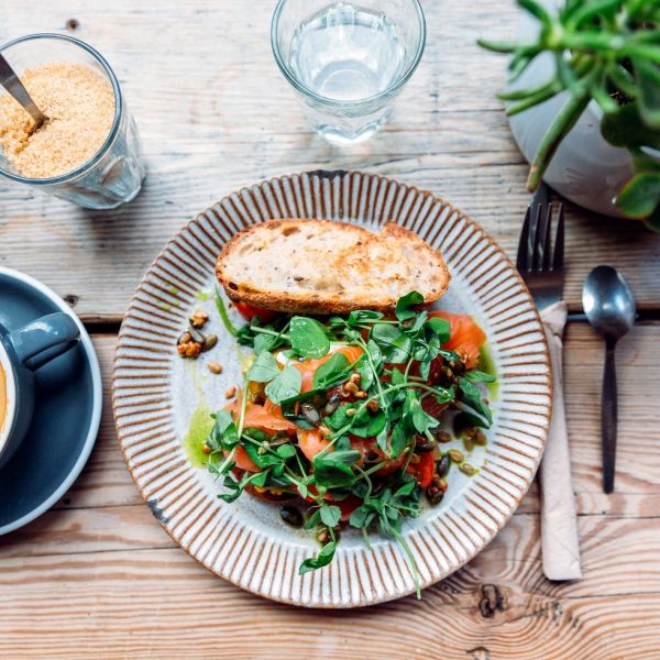 avocado toast with salmon and cup of cappuccino, high angle view