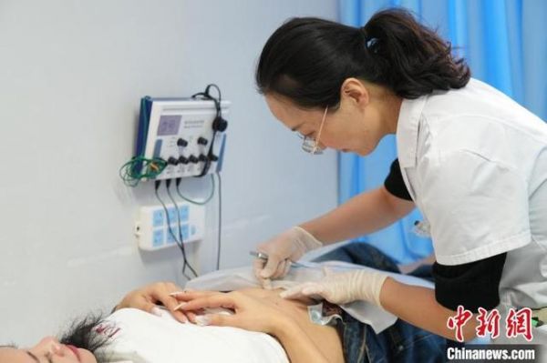 图为医生为患者进行穴位埋线。闫龙摄