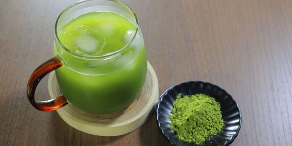 iced matcha in a transparent coffee mug cup. green tea with iced cubes