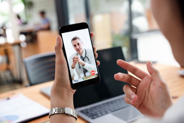 PHOTO: Businesswoman talking with doctor online from office.