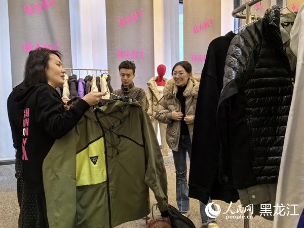 导购向顾客介绍服装的设计理念。人民网 尚城摄