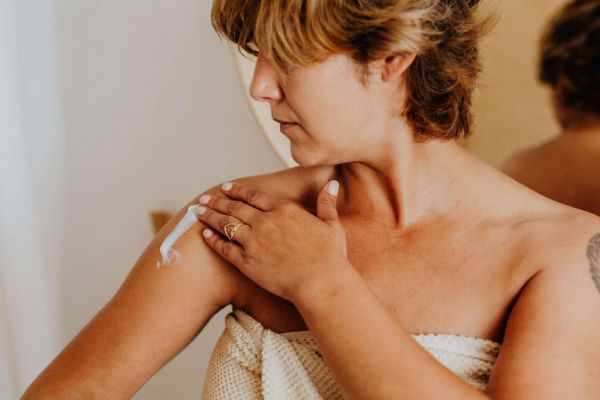 Woman putting on lotion