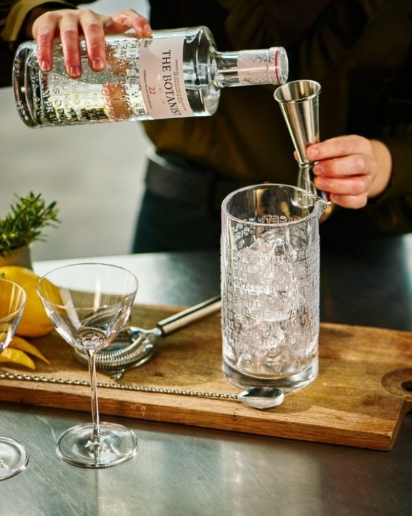 A person pouring a drink into a glass Description automatically generated