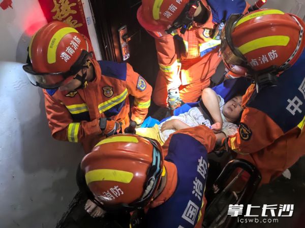 消防员抬起孕妇紧急送医。 长沙晚报通讯员 龙伟杰 供图